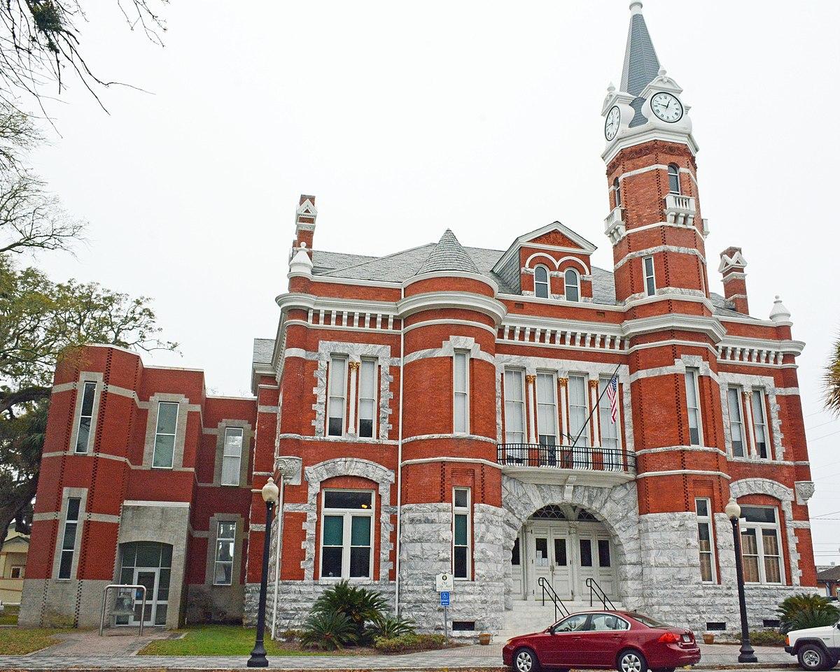 A red brick building with a clock tower

Description automatically generated